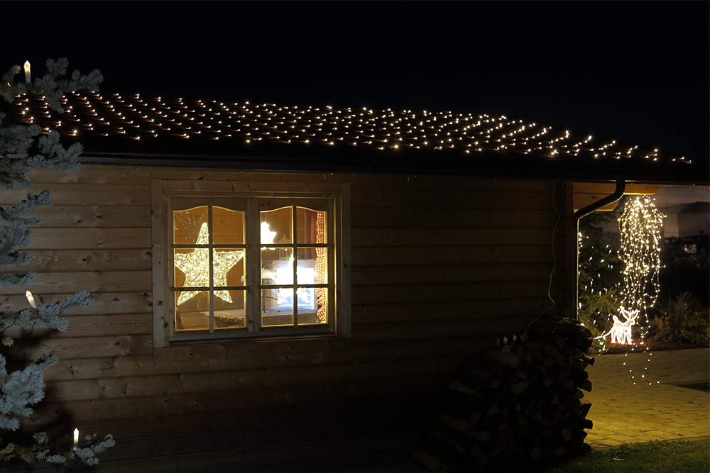 Weihnachtsdekoration: Lichternetz auf dem Dach der Hütte