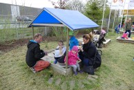 Kinder beim Spielen bei Regen im Sandkasten mit Dach